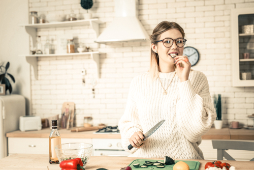 Young woman eating with eyeglasses