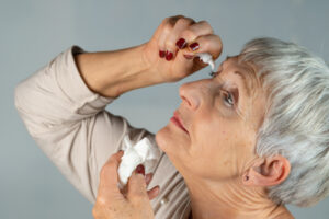 Older woman using eye drops