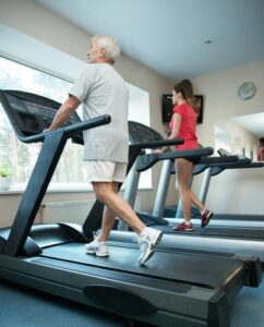 A man and a woman using treadmills next to each other